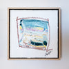 Framed abstract artwork with a signature on a white wall