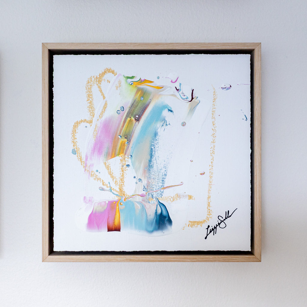 Framed abstract artwork with colorful brush strokes on a white background