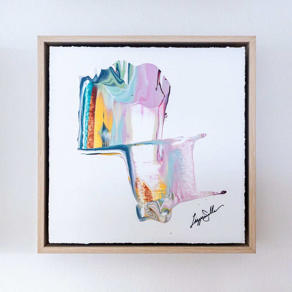 Framed abstract artwork with colorful brush strokes on a white background