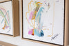 Framed abstract art pieces with colorful brushstrokes on a white wall.