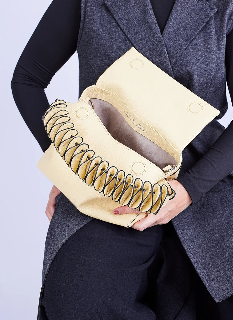 Person holding a yellow handbag showing interior lining
