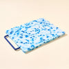 Blue and white speckled cutting board with a blue handle on a beige background