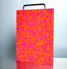 Pink and orange patterned cutting board on a light gray background