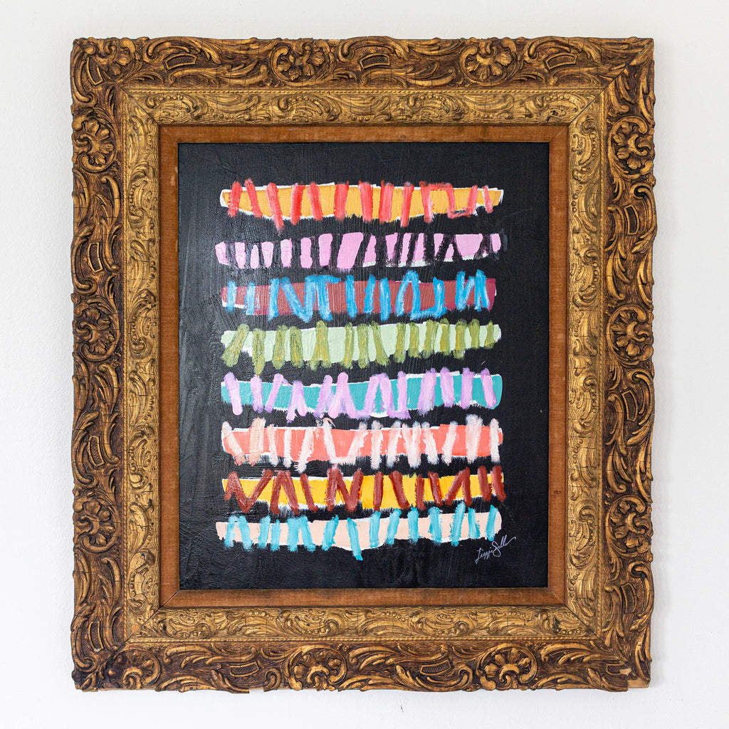 Framed abstract artwork with colorful horizontal stripes on a black background