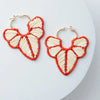 Raffia Earrings in tan and coral on white background

