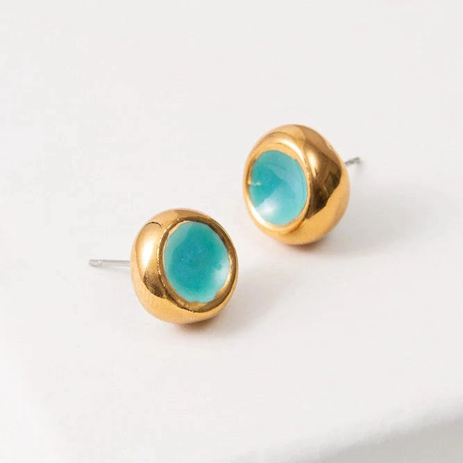 Gold stud earrings with turquoise accent on a white background