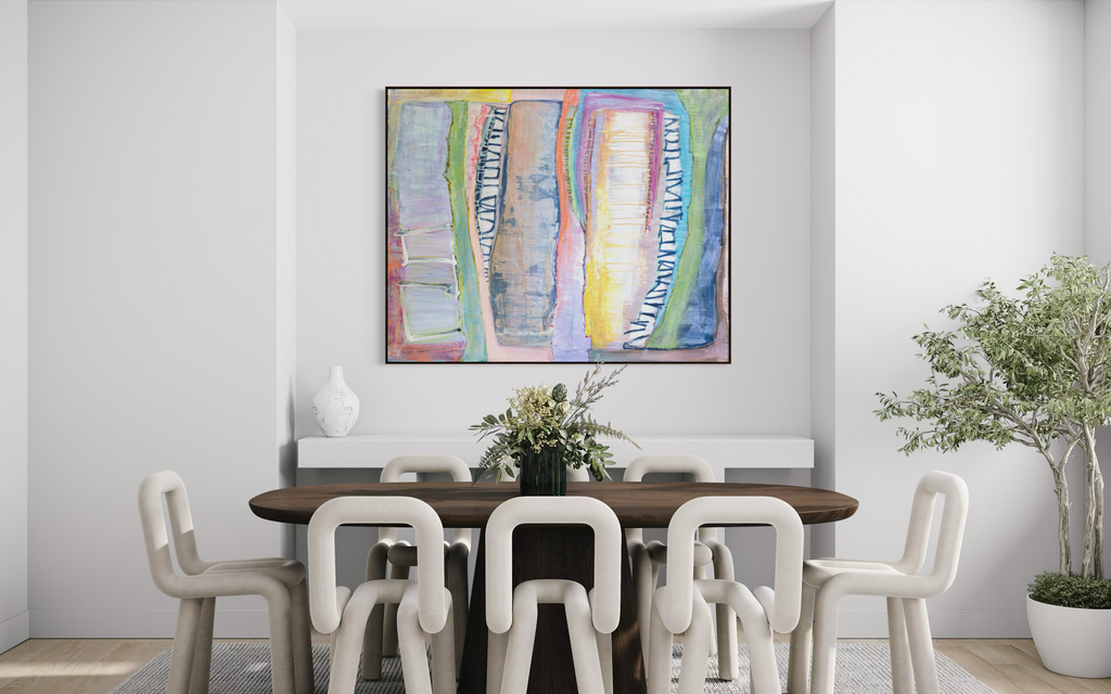A colorful abstract wall art print hangs above a dark wood dining table with white chairs in a bright, modern dining room. The artwork features vertical brushstrokes in blue, yellow, pink, green, and purple.