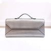A metallic silver pebbled leather clutch handbag with a top handle, shown against a clean white background.