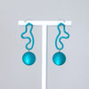 Pair of turquoise earrings with spherical beads on a white background