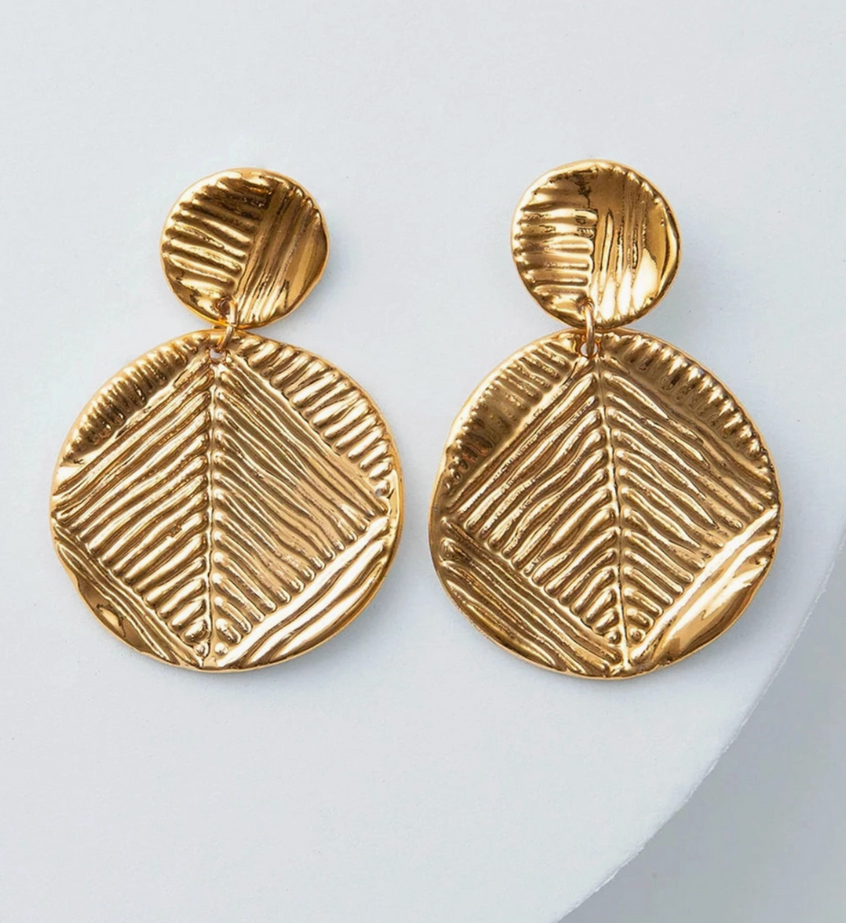 Pair of gold earrings with textured design on a light gray background