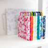 Colorful patterned cutting boards on a white shelf