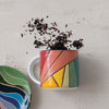 Colorful mug and coaster set on a textured surface