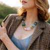 Woman wearing a plaid jacket and colorful necklace outdoors